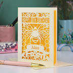 Laser-cut husband birthday card with cut out bee design and 'Happy 60th Birthday Alan' text on a yellow background.