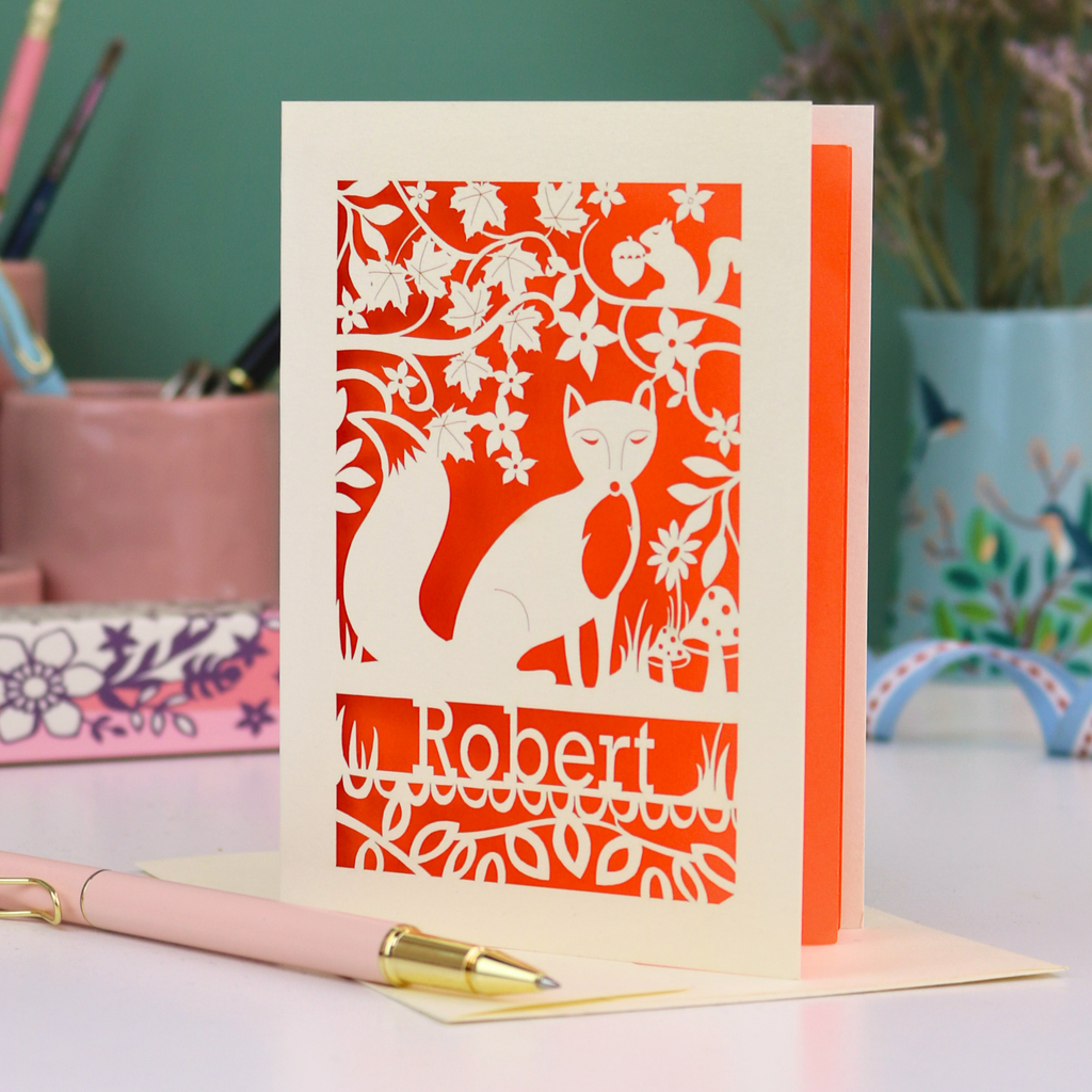 Laser cut birthday Card with fox design and 'Robert' text on a desk with stationery items.