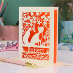 Laser cut birthday Card with fox design and 'Robert' text on a desk with stationery items.