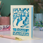 Laser cut birthday Card with fox design and 'Robert' text on a desk with stationery items.