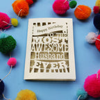 Laser cut Husband Birthday card for the most awesome husband ever on a blue background with colourful pom-poms.