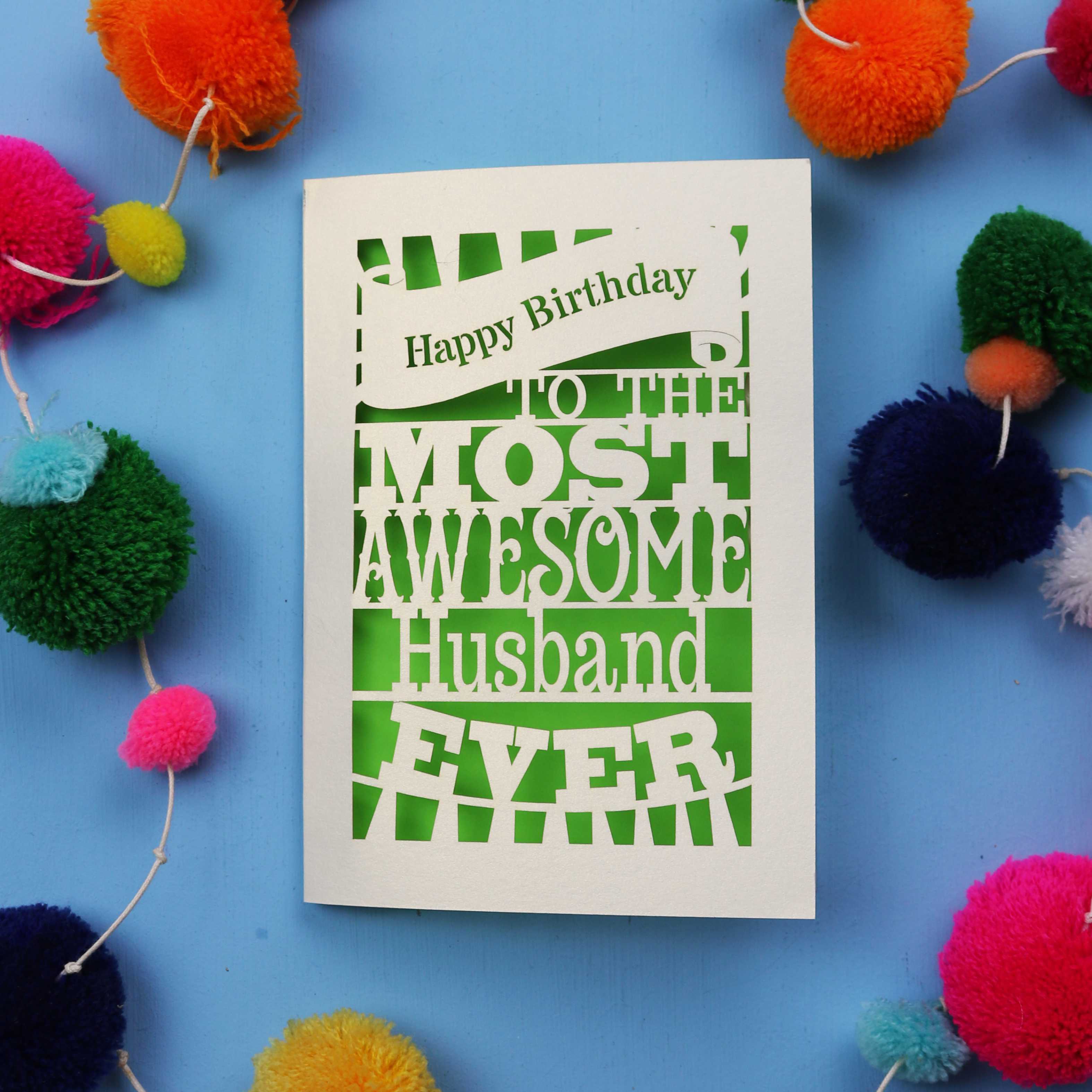 Handmade in the UK, a Husband Birthday card for the most awesome husband ever on a blue background with colourful pom-poms.