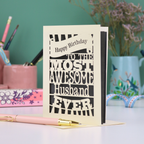 A cream and grey paper cut Husband Birthday card with cut out text design - "Happy Birthday to the most awesome husband ever"