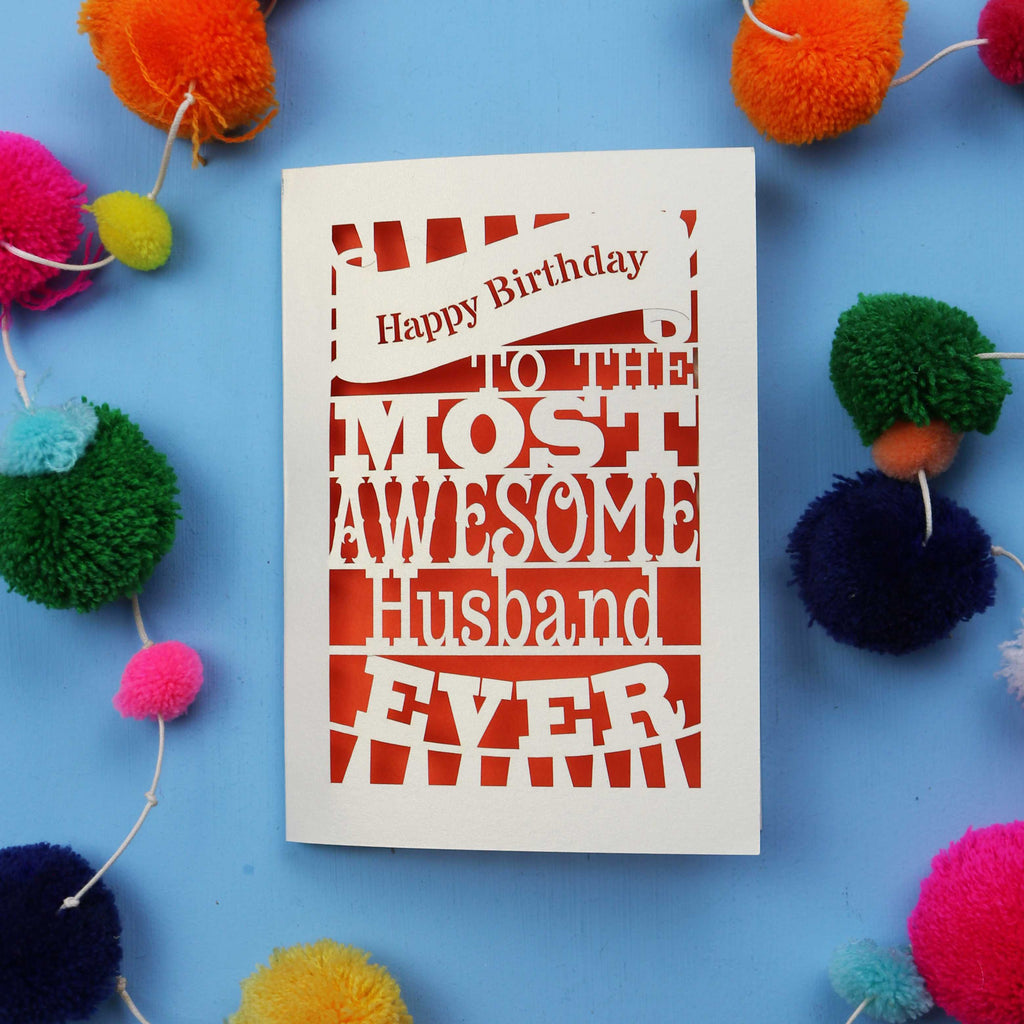 Husband Birthday card for the most awesome husband ever on a blue background with colourful pom-poms.