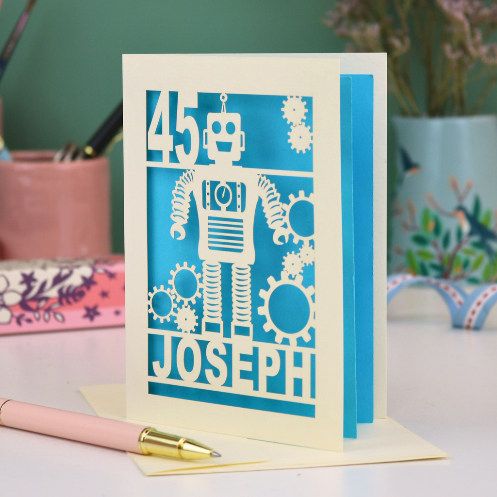 A laser cut birthday card with robot design, personalised with the age '45' and the name 'Joseph'
