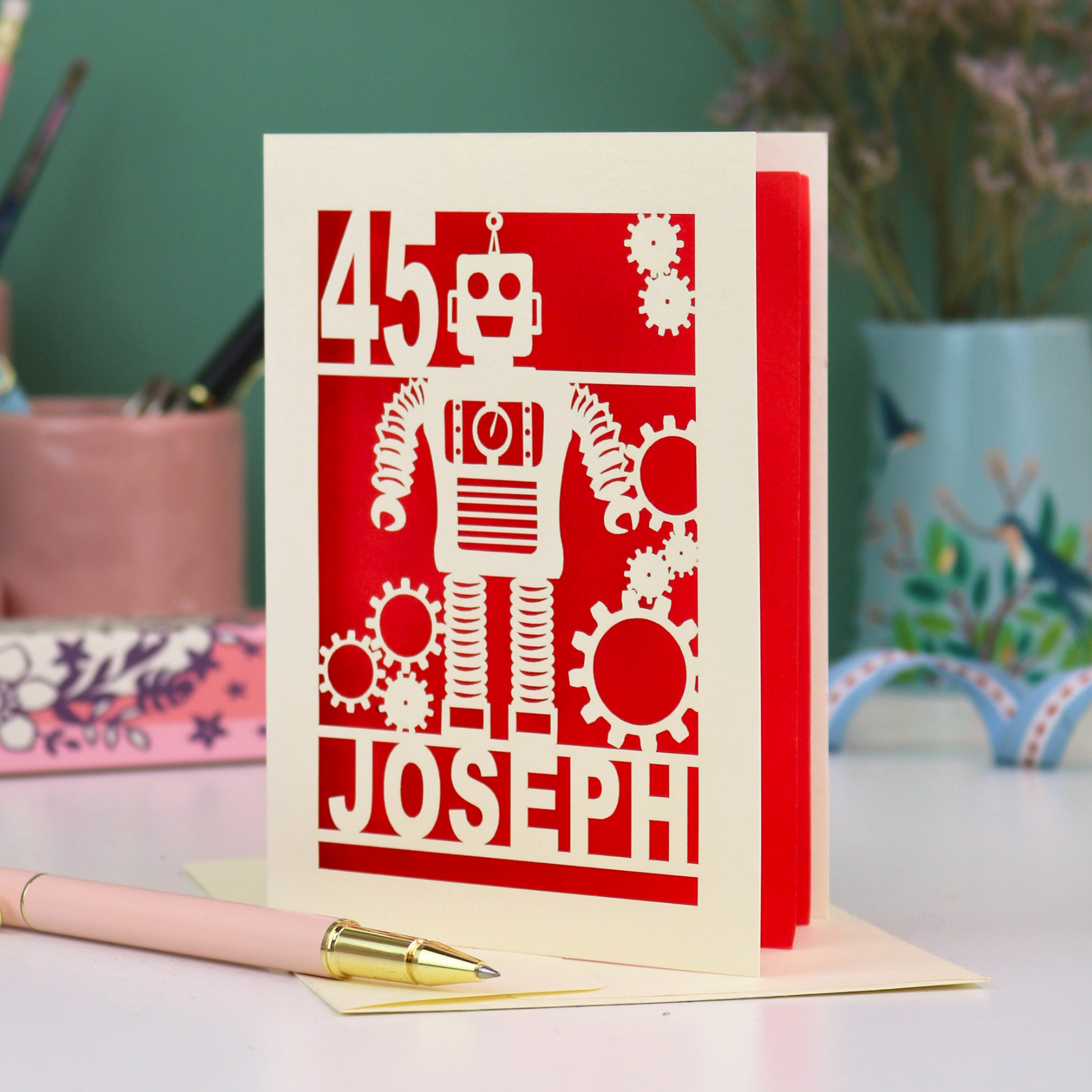 A laser cut birthday card with robot design, personalised with the age '45' and the name 'Joseph'