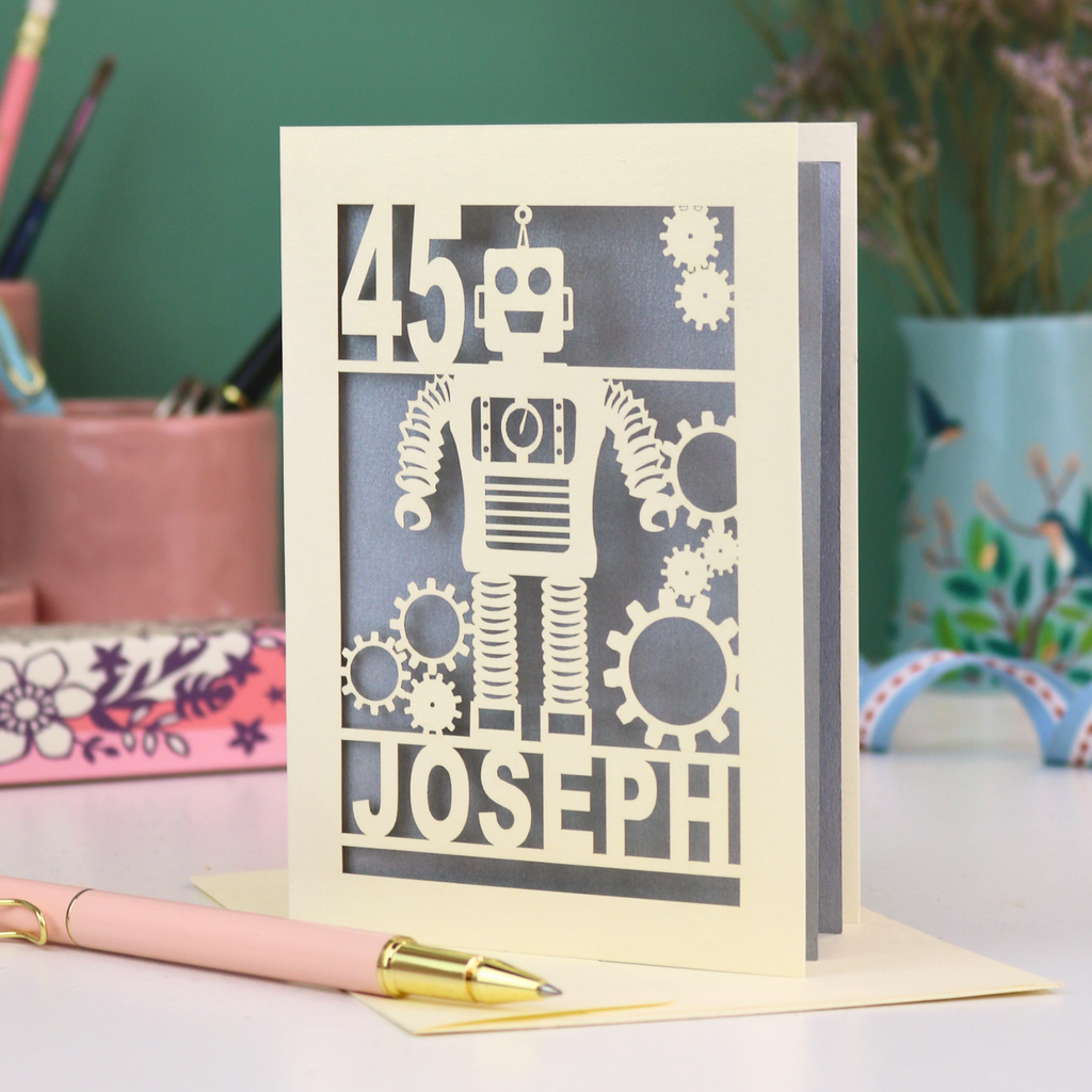 A laser cut birthday card with robot design, personalised with the age '45' and the name 'Joseph'