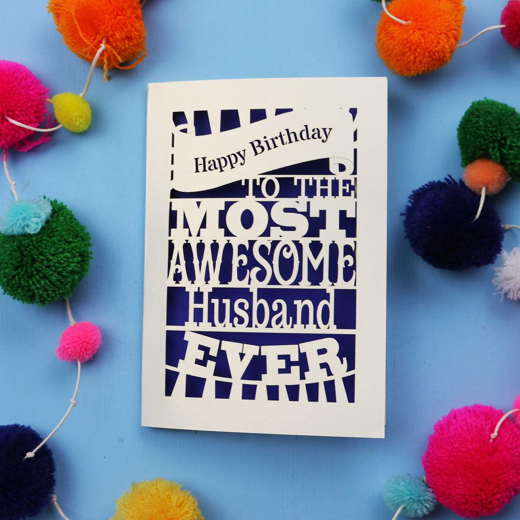 Husband Birthday card for the most awesome husband ever on a blue background with colourful pom-poms.