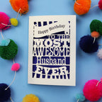 Husband Birthday card for the most awesome husband ever on a blue background with colourful pom-poms.