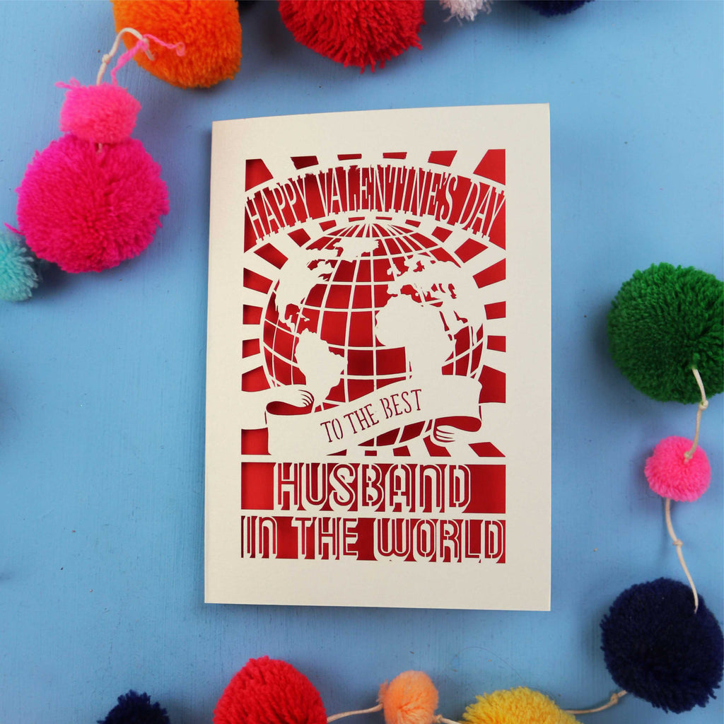 Husband Valentine's Card with 'Happy Valentine's Day' and 'To the best husband in the world' text on a blue background with colourful pom-poms.