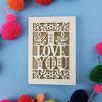 Valentine's Card with 'I LOVE YOU' design surrounded by colourful pom-poms on a blue background