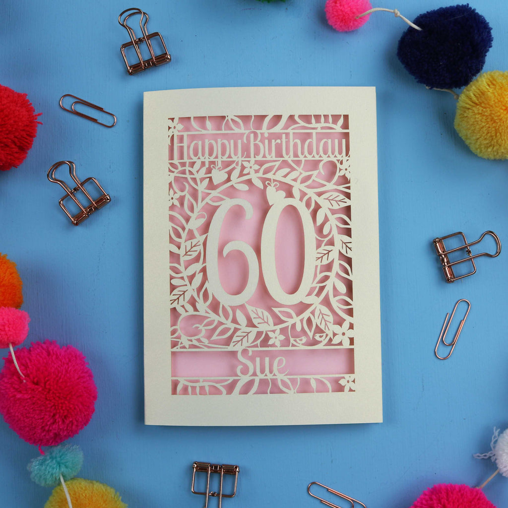 60th Birthday card with 'Happy Birthday 60 Sue' on a blue background with colourful pom-poms and paper clips.