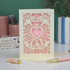 A detailed floral cream and pink laser cut card with heart shape in the centre and two banners, one above with "Kindness" and one below with "is everything". 