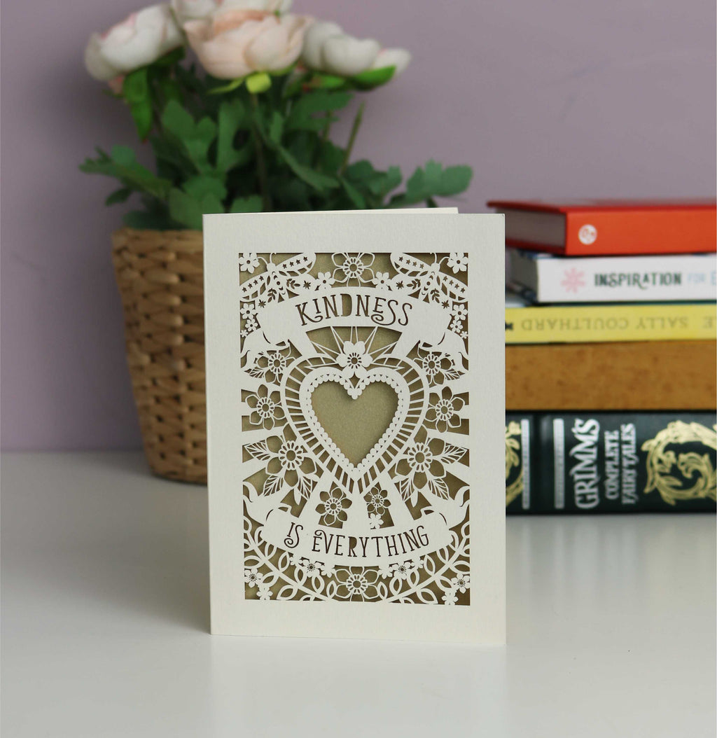 Elegant papercut "Kindness is everything" card. Shows a heart, flowers, butterflies and banners with the text. Beautiful in cream card with a gold insert mpaper.