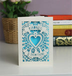 Gorgeous cream and peacock blue papercut card with Kindness is everything on two banners. A central heart with butterflies and flowers around.