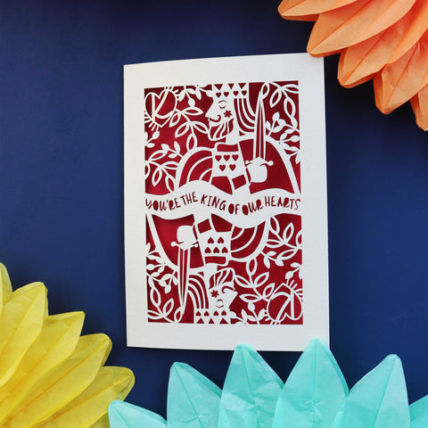 A laser cut father's day card that says "You're the king of our hearts" 
