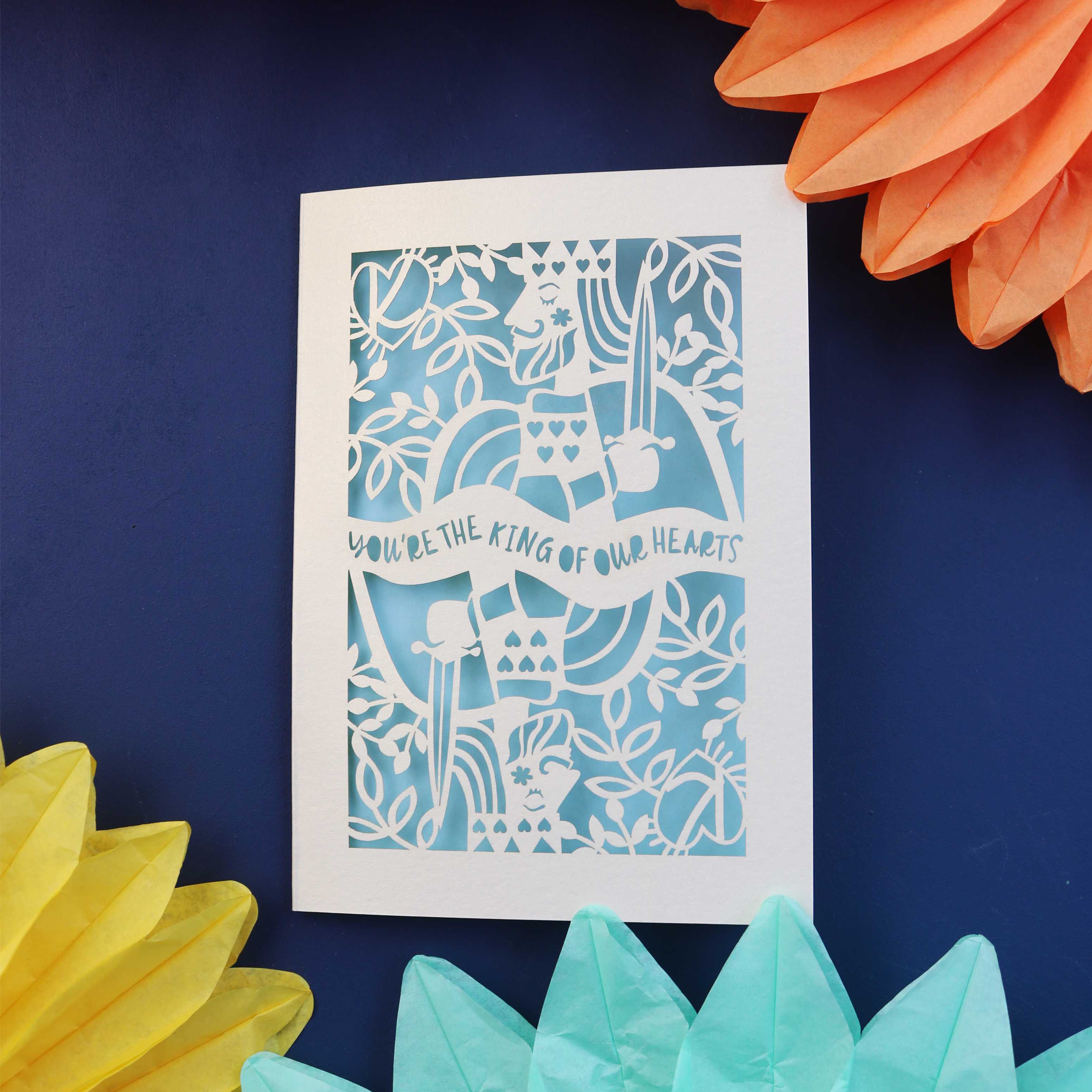 A cut out fathers day card that says "You're the king of our hearts"