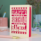 A laser cut personalised birthday card that says "Happy Birthday Rachel" in bold text with star design.