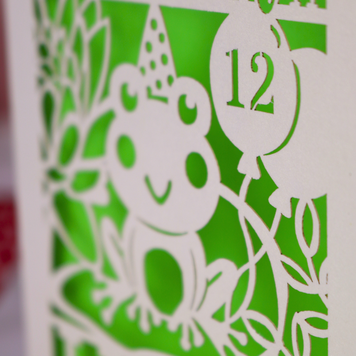 A close up of a laser cut frog birthday card