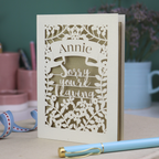 Laser cut leaving Card with 'Sorry you're leaving' message on a desk with decorative items.