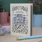 Laser cut leaving Card with 'Sorry you're leaving' message on a desk with decorative items.