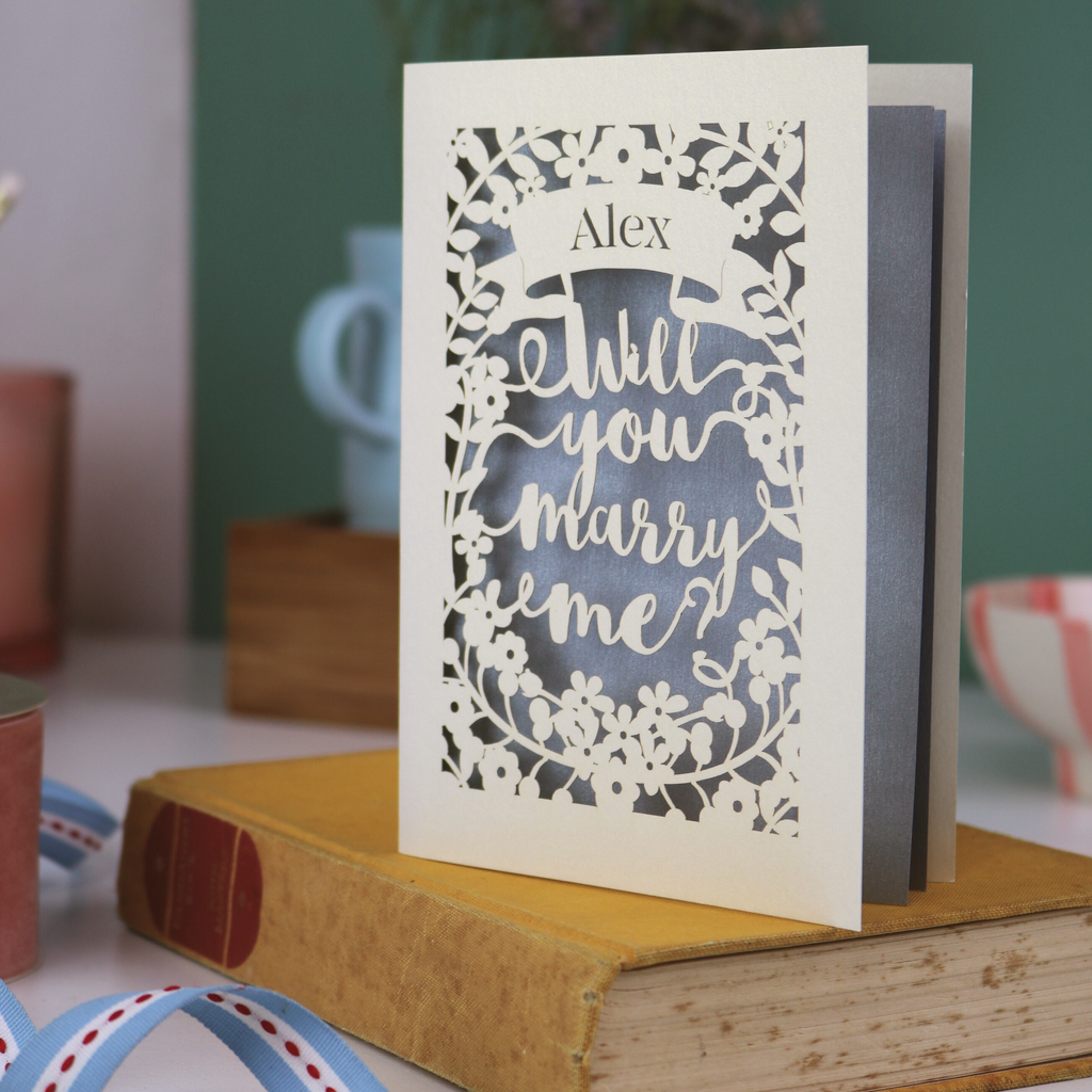 Proposal card with 'Will you marry me?' on a book