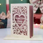 A laser-cut wedding card with an intricate heart-shaped design and the text 'Mr. and Mrs. Young, 09/10/26'