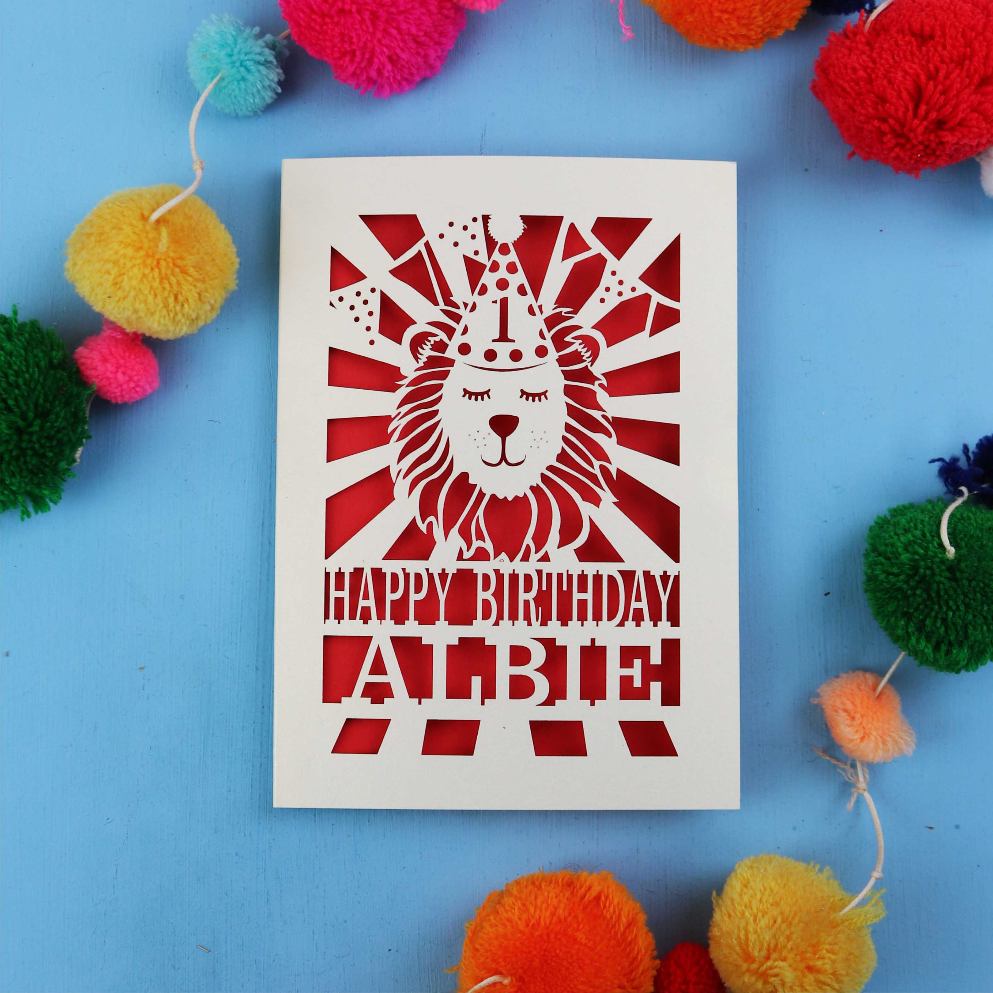 Unique 1st Birthday card with lion design and colourful pom-poms on a blue background