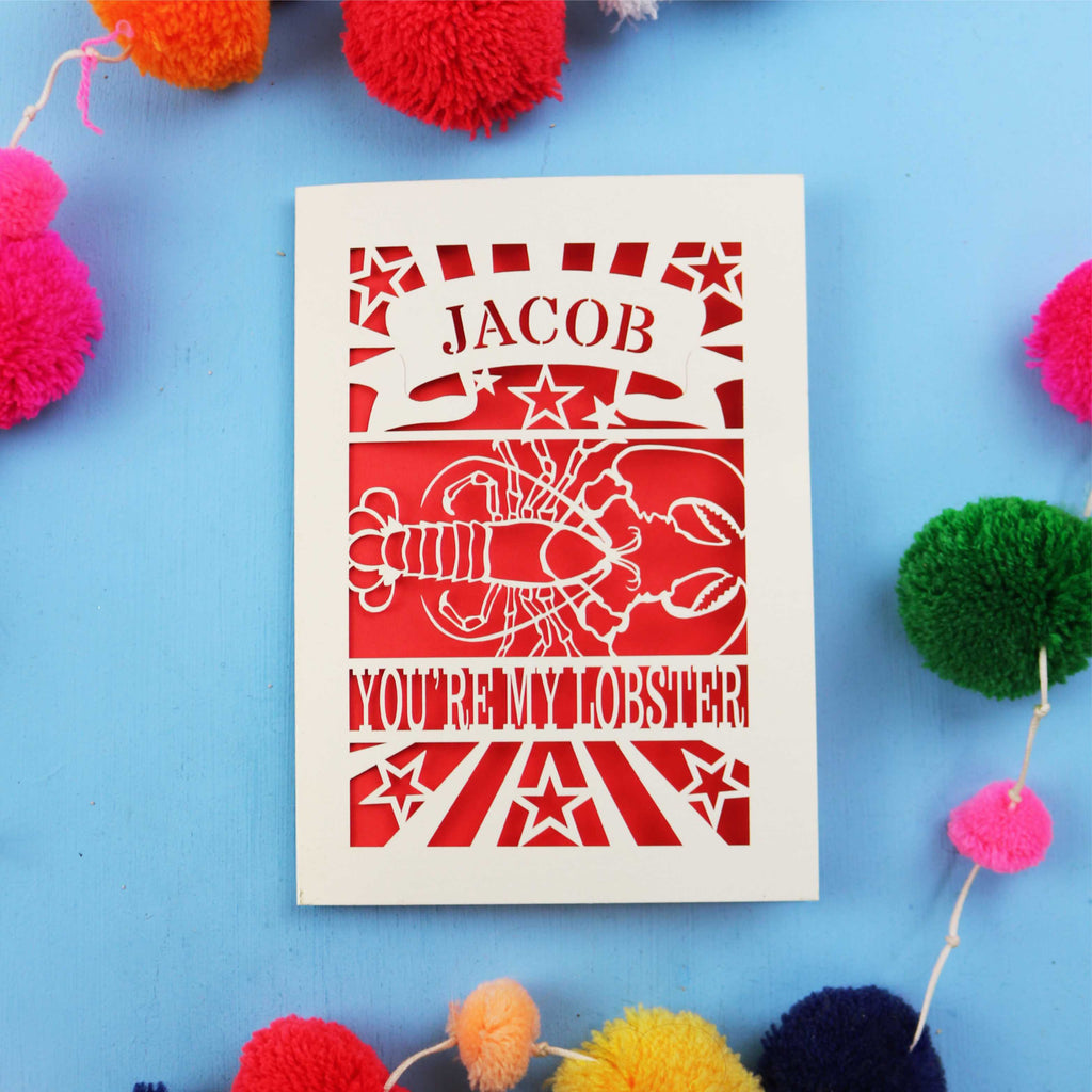 Funny Valentine's Card with 'Jacob, you're my lobster' design on a blue background with colourful pom-poms.