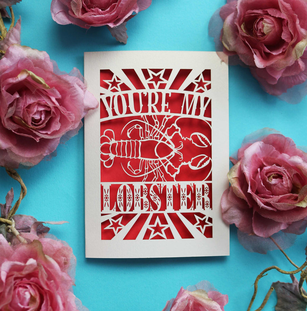A paper cut Valentine's card that says "You're My Lobster" with a cut out design of a lobster