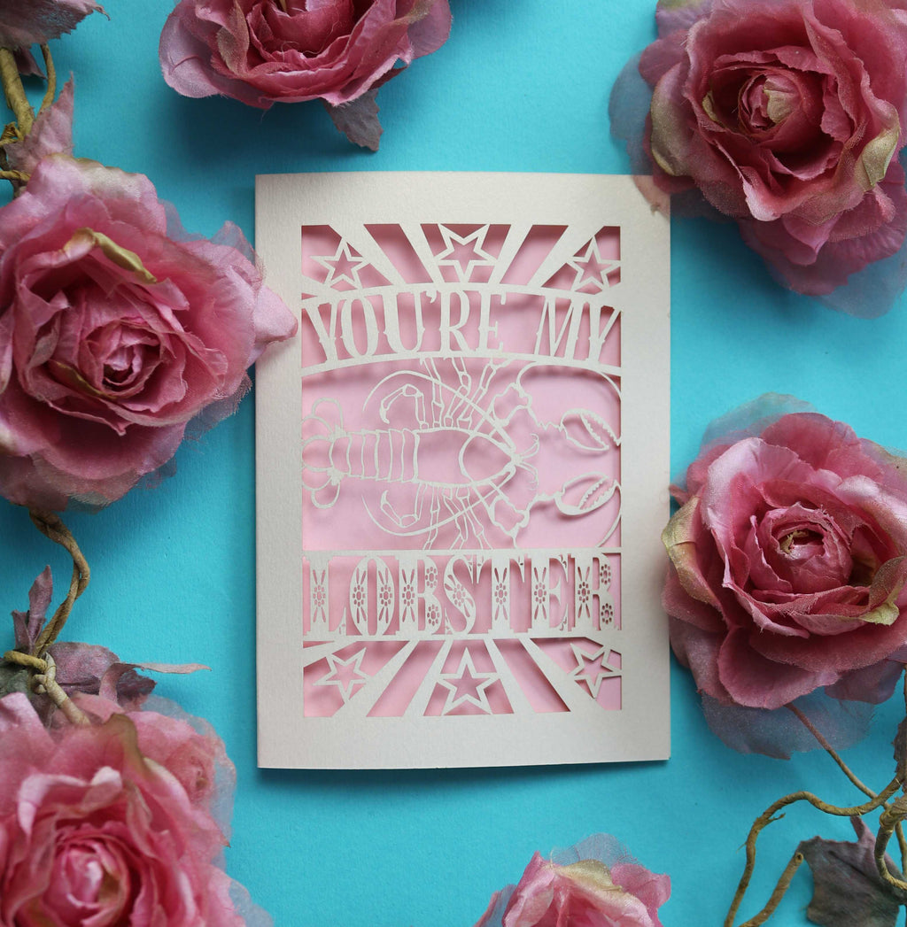 A laser cut Valentines card that says "You're My Lobster" with a cut out design of a lobster