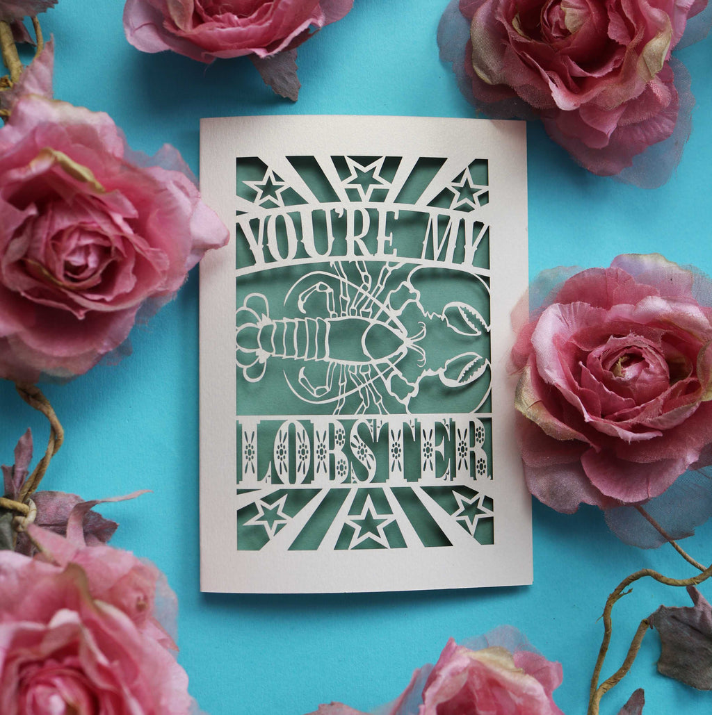 A laser cut Valentine's card that says "You're My Lobster" with a cut out design of a lobster