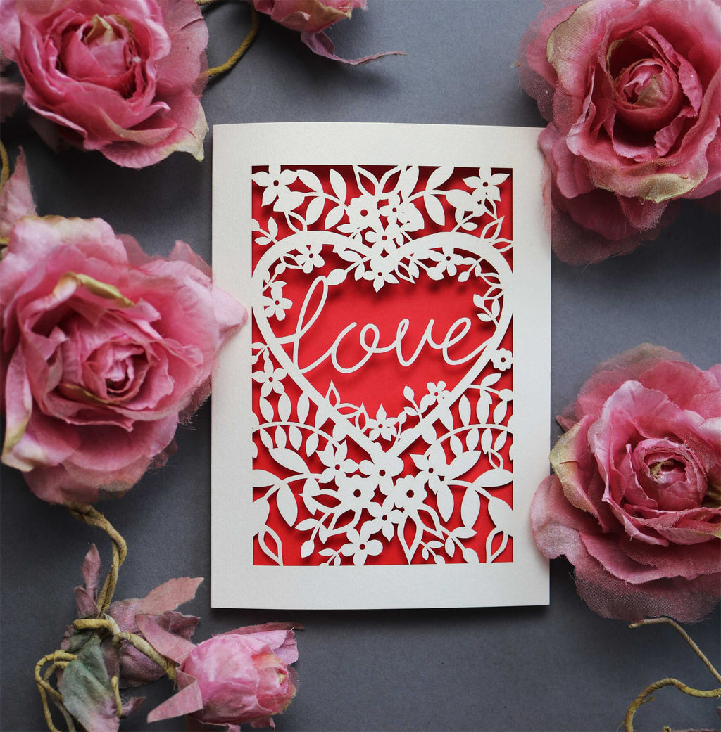 Laser cut engagement card with 'love' inside a floral heart design 