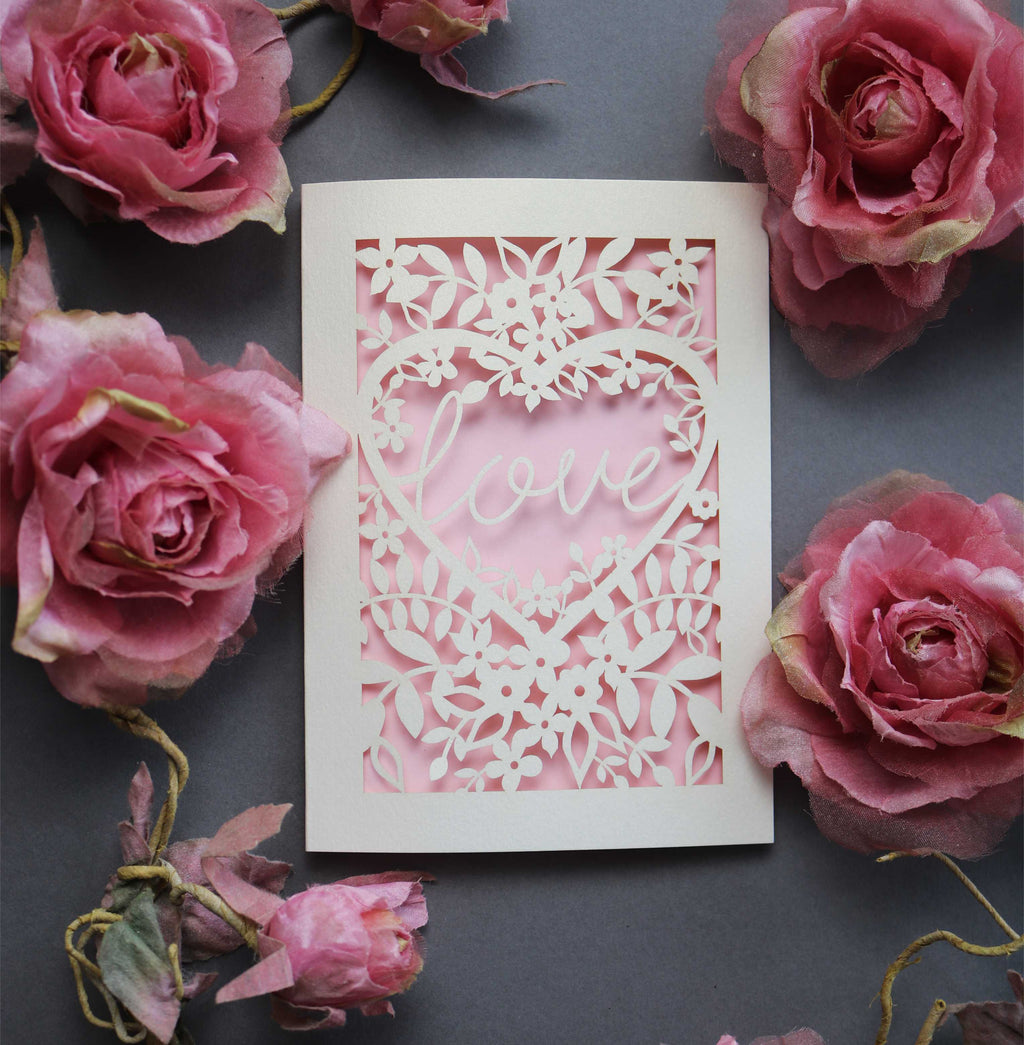 Laser cut engagement card with 'love' inside a floral heart design 