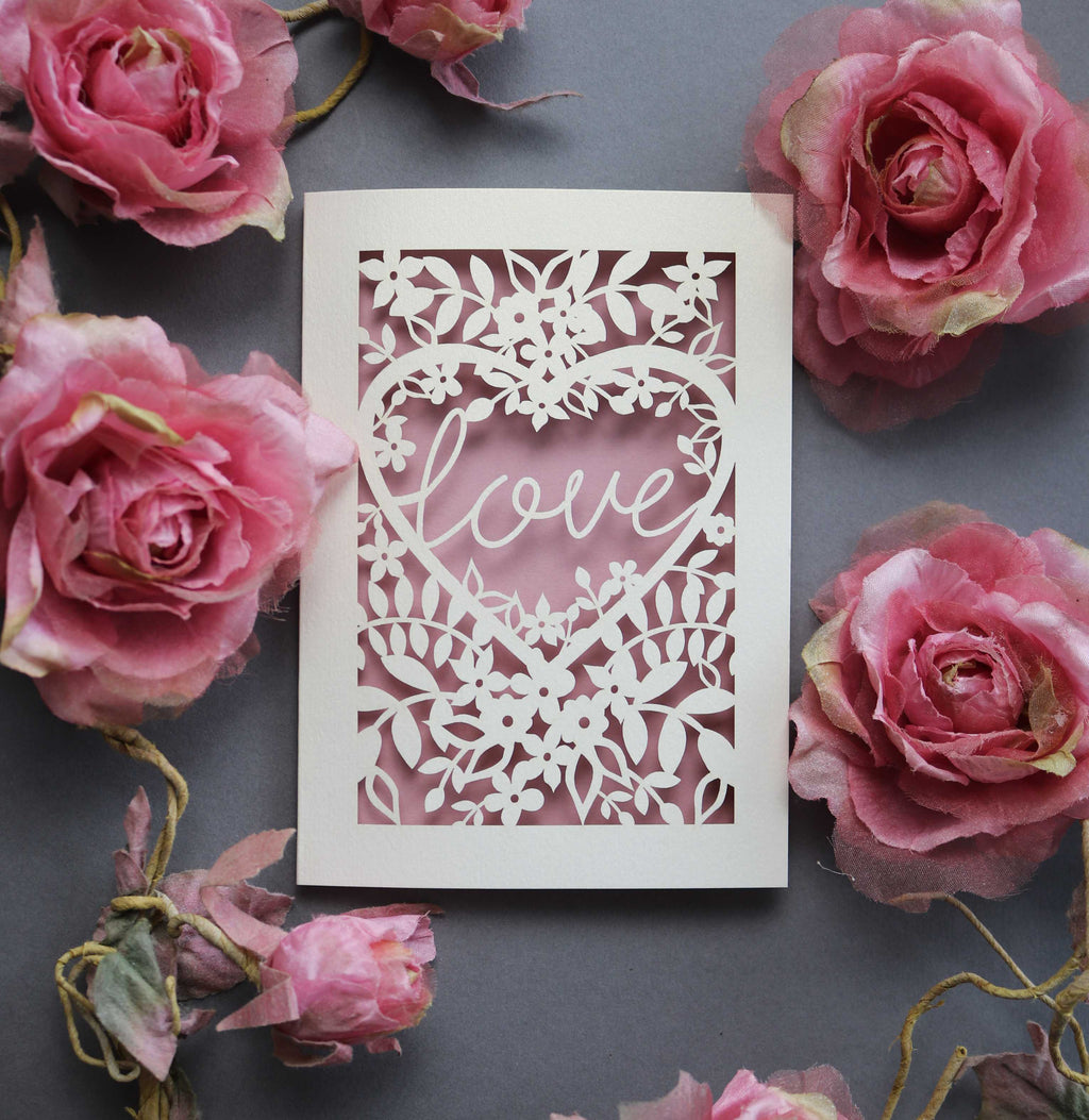 Laser cut engagement card with 'love' inside a floral heart design 