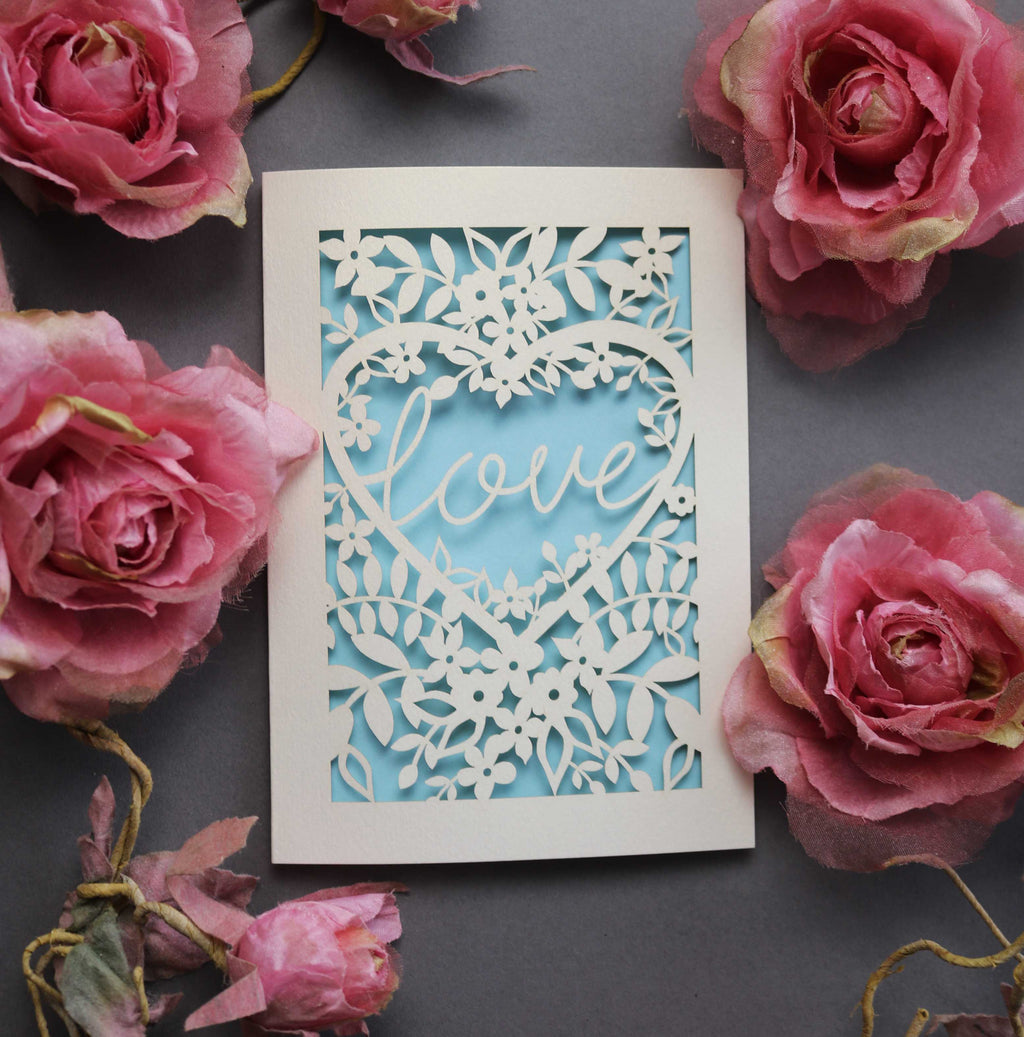 Laser cut engagement card with 'love' inside a floral heart design 