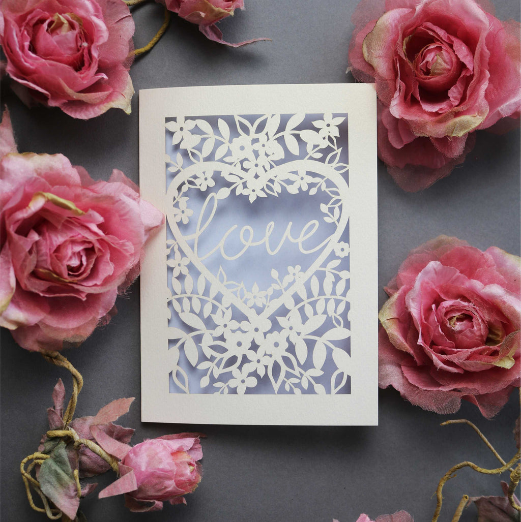 Laser cut engagement card with 'love' inside a floral heart design 