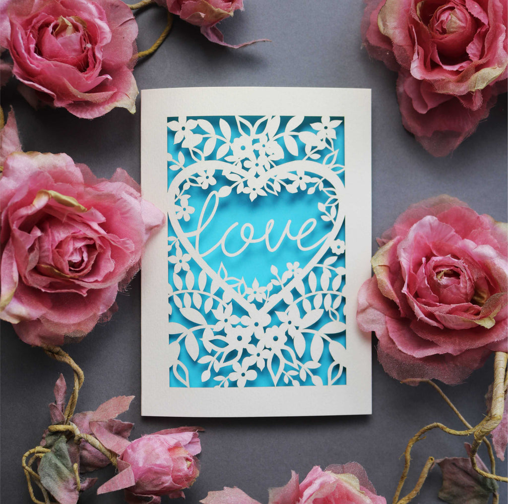 Laser cut engagement card with 'love' inside a floral heart design 