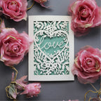 Laser cut engagement card with 'love' inside a floral heart design 