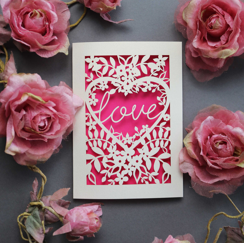 Laser cut engagement card with 'love' inside a floral heart design 