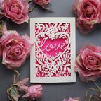 Laser cut engagement card with 'love' inside a floral heart design 