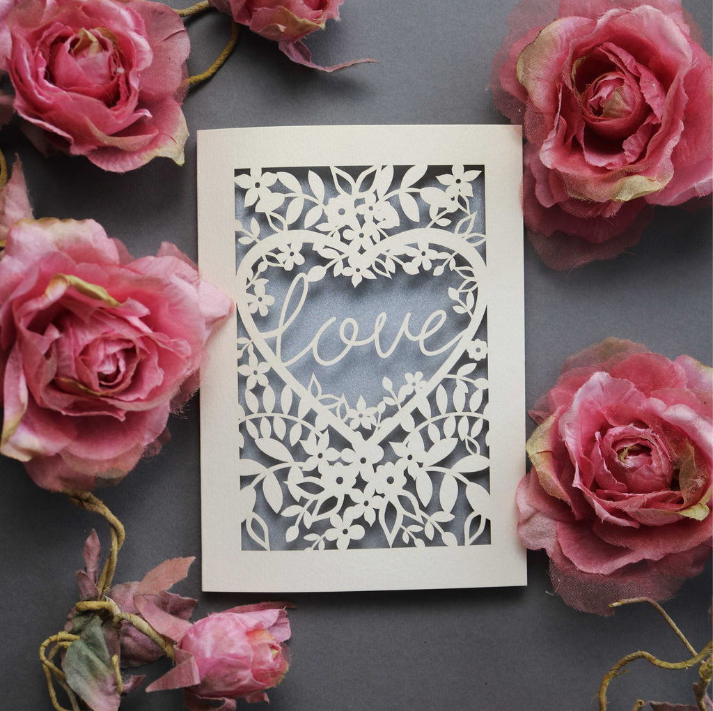 Laser cut engagement card with 'love' inside a floral heart design 