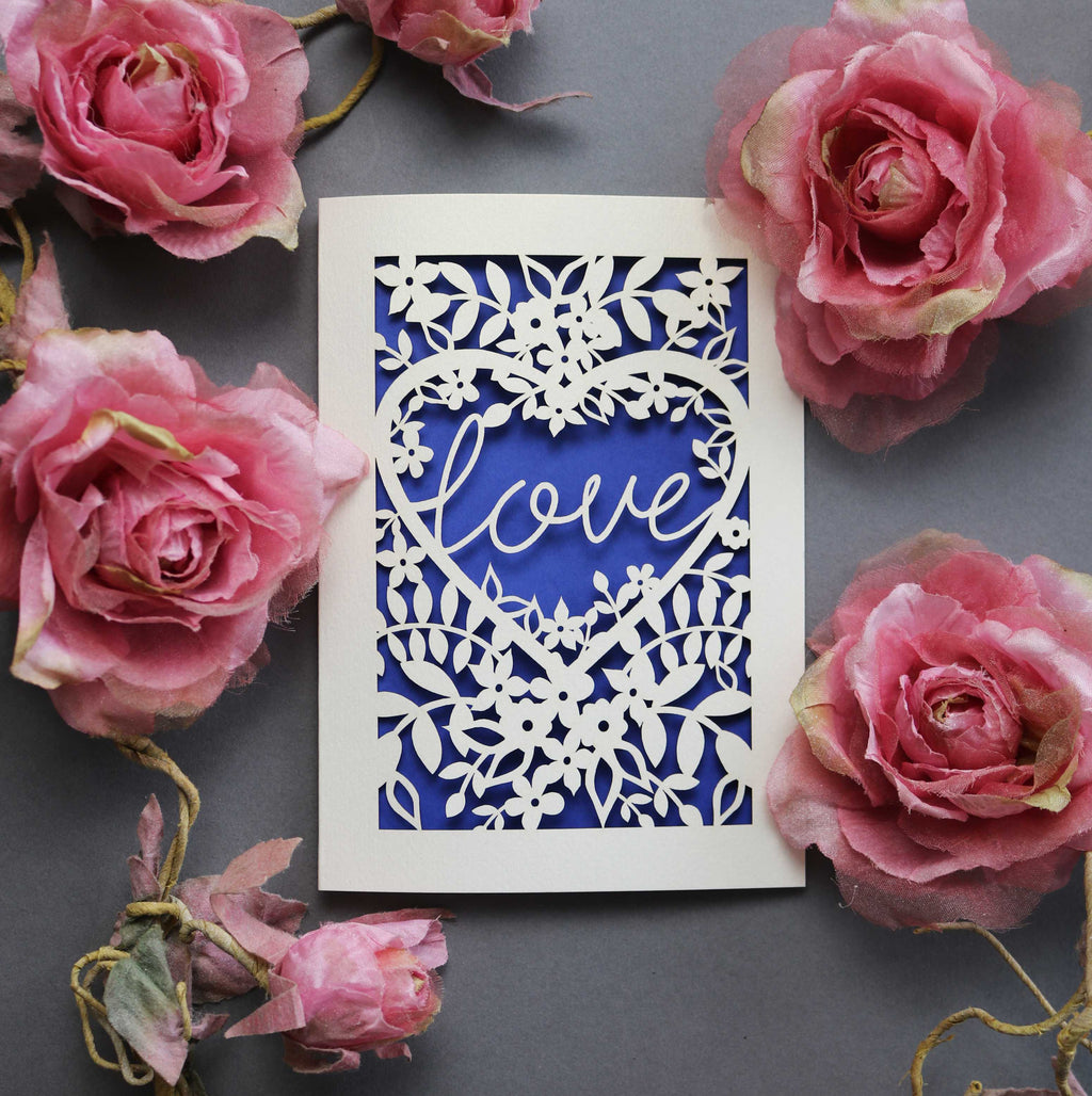 Laser cut engagement card with 'love' inside a floral heart design 