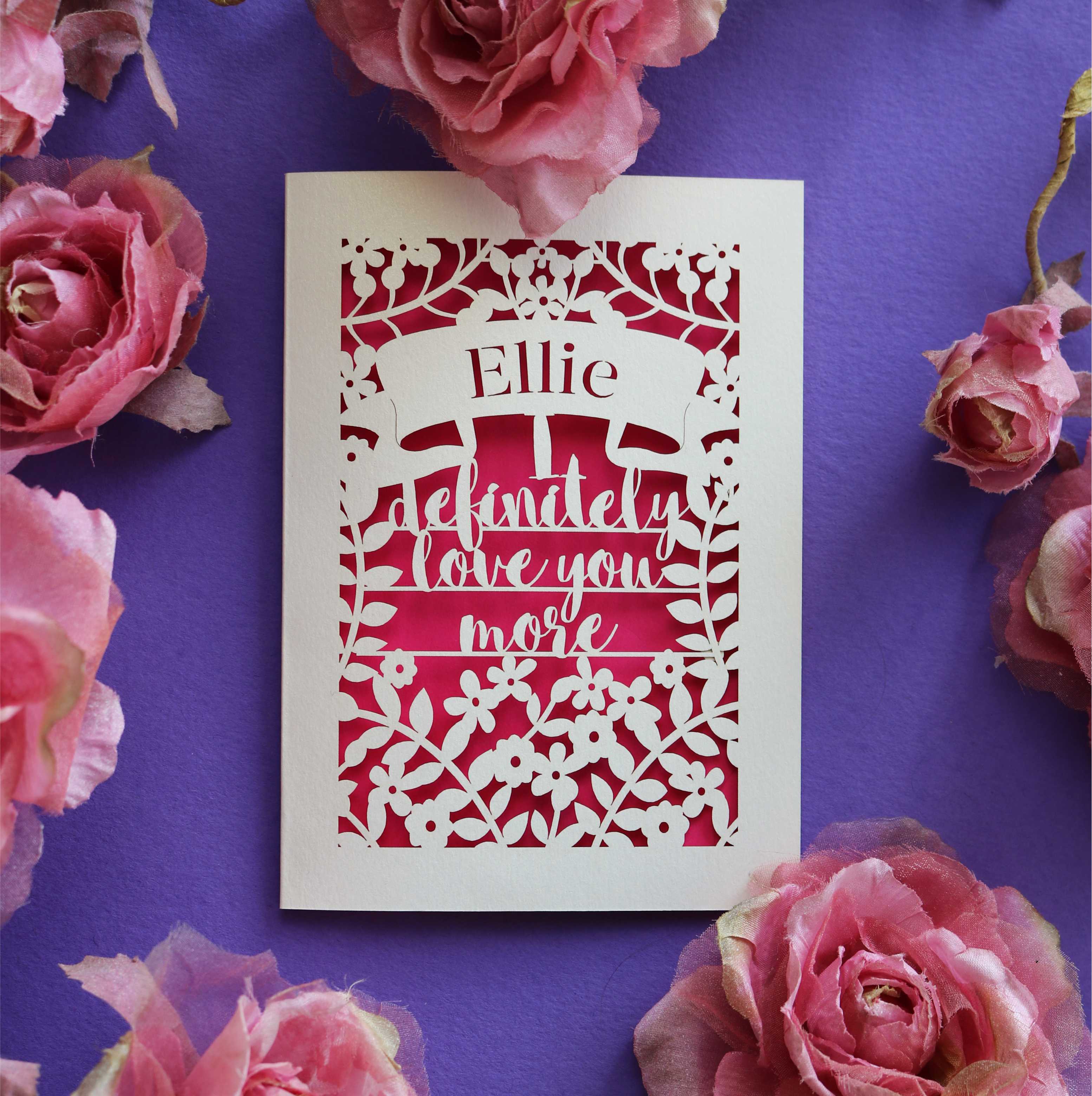 A personalised cut out Valentine's card that says "I definitely love you more"