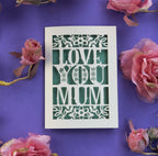 A cream and sage green Mother's Day card, laser cut with the words "Love you mum"