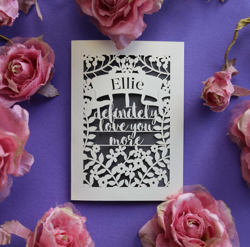 A laser cut personalised Valentine's card that says "I definitely love you more"