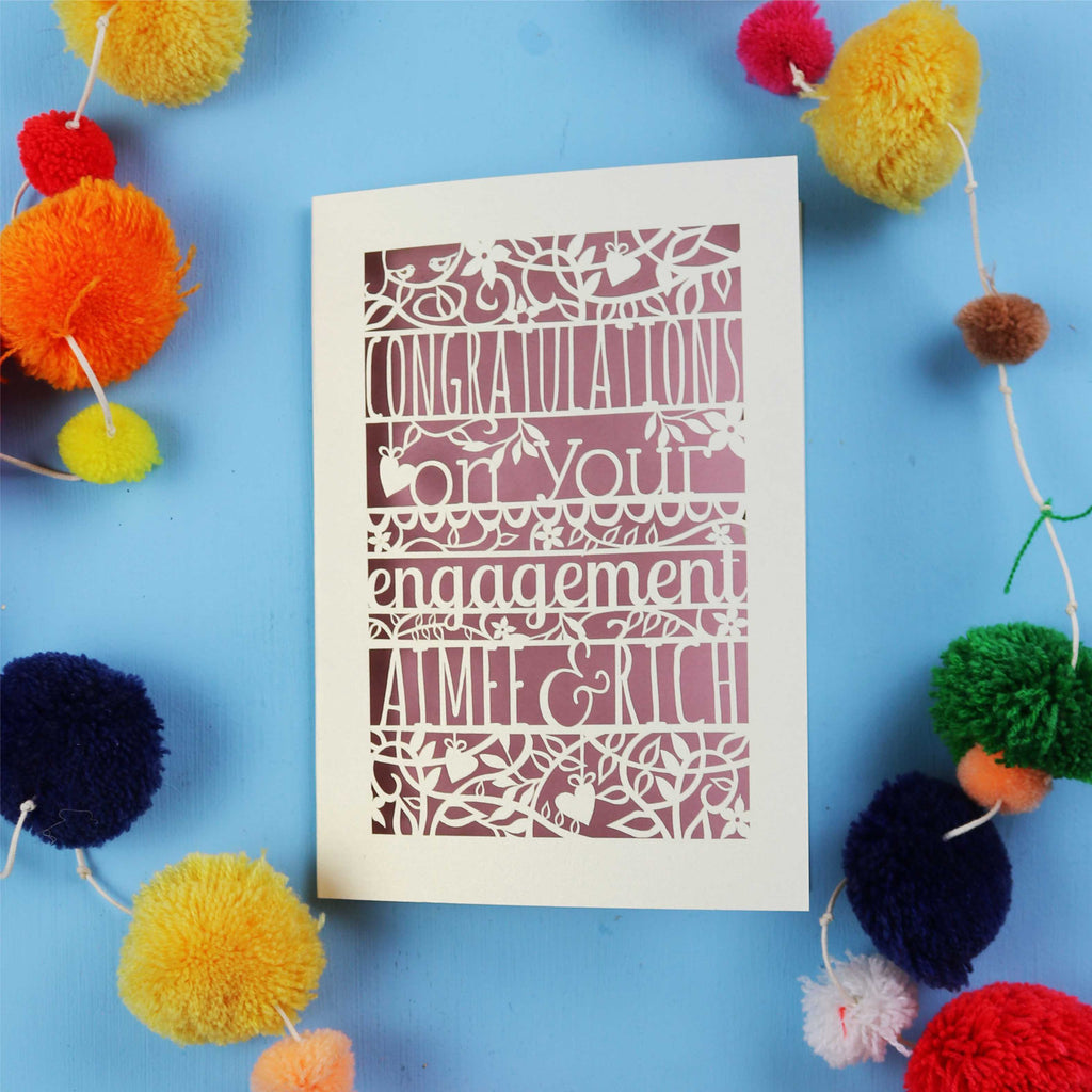 Luxury engagement Card made in the UK, with 'Congratulations on your engagement' text on a blue background with colourful pom-poms.