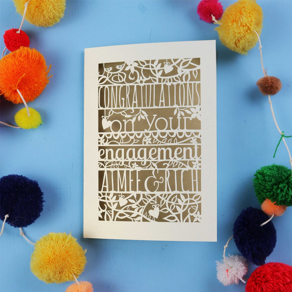 Personalised Luxury laser cut engagement Card with 'Congratulations on your engagement' text on a blue background with colourful pom-poms.
