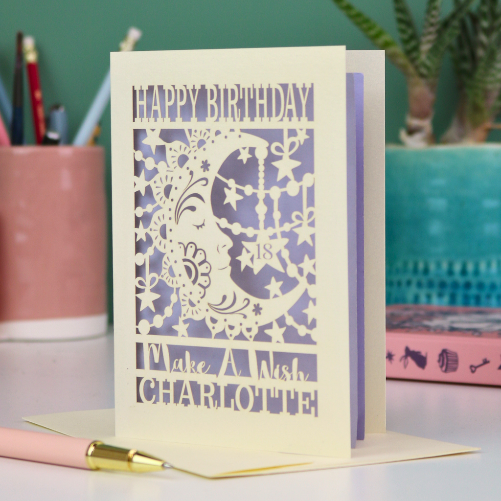 Luxury Laser-cut birthday card with decorative moon and star elements on a desk with stationery items.
