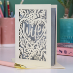 Luxury Card with 'Wife' cut out design on a desk with stationery items.